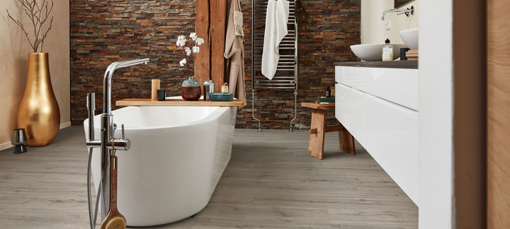Bad mit Wanne auf grauem Designboden.