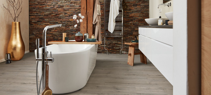 Bad mit Wanne auf grauem Designboden.