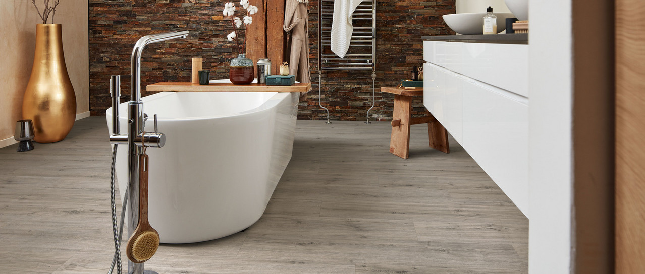 Bad mit Wanne auf grauem Designboden.
