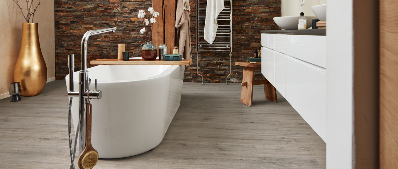 Bad mit Wanne auf grauem Designboden.