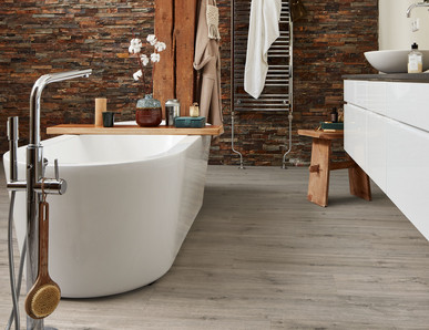 Bad mit Wanne auf grauem Designboden.