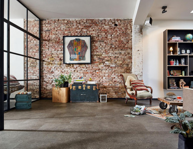Loft-Wohnraum mit Ziegelwand und dunklem Designboden.