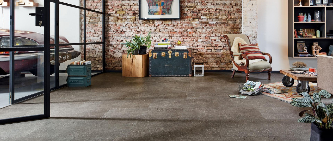 Loft-Wohnraum mit Ziegelwand und dunklem Designboden.