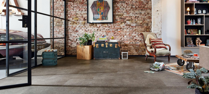 Loft-Wohnraum mit Ziegelwand und dunklem Designboden.
